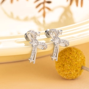 Elegant silver bow stud earrings with sparkling clear cubic zirconia on a warm background