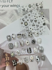 Detail of silver metallic Y2K nail art stickers featuring hearts and stars motifs