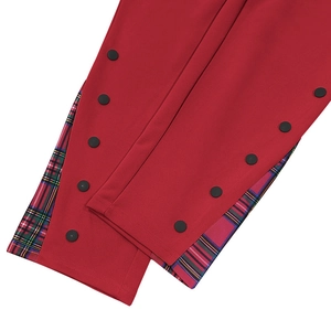 Détail de pantalon rouge robuste montrant le patchwork à carreaux et le bouton-pression