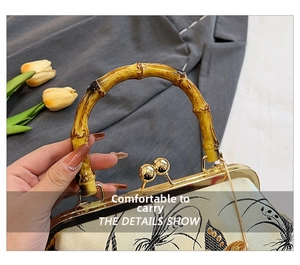 Detail of bamboo handle and metal frame on Chinese style embroidered handbag