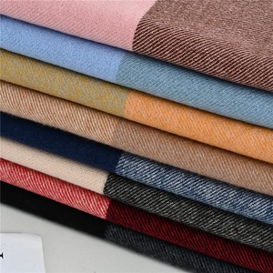 Detailed macro view of twill weave texture and colorful plaid patterns on soft scarves