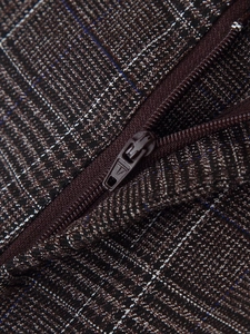 Vue macro détaillée de la fermeture éclair et de la texture du tissu à carreaux marron