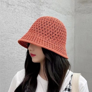 Detailed close-up of the orange-red crochet knit pattern on the summer bucket hat