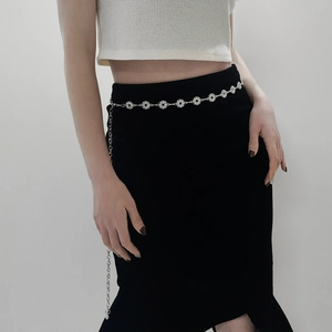 Close-up of a silver rhinestone metal chain belt with sparkling round buckle links