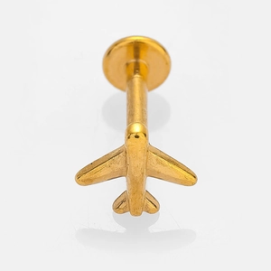 Macro detail of a golden airplane-shaped labret stud with turquoise inlay and flat back