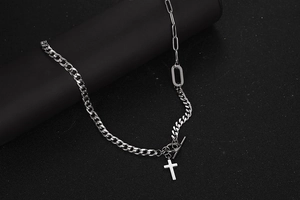 Close-up of silver cross pendant with mixed Cuban and long link chain textures