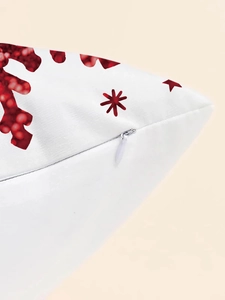 Detail of invisible zipper closure and red snowflake print on white fabric pillow cover