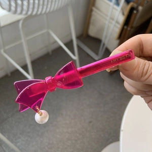 Pink acetate floral bow hair clip with a white pearl pendant and AMY BEAR lettering