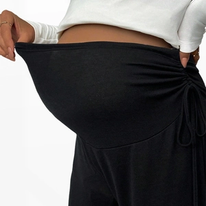 Detail of adjustable elastic waistband with button on maternity pregnancy trousers