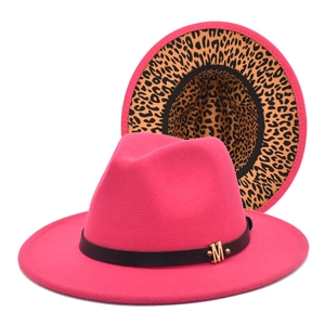 Detail of rose red fedora with black ribbon, golden M buckle, and leopard print brim lining
