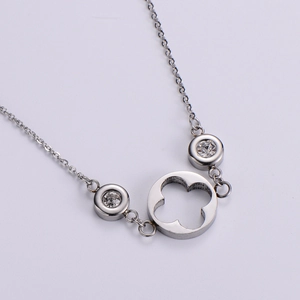 Elegant silver clover necklace set with clear zircon stones on a clean white background