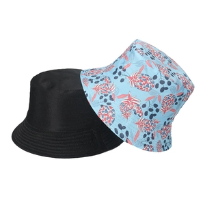 Detail of reversible bucket hats in black and light blue pineapple fruit print pattern