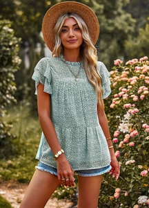 Close-up of floral print pattern and ruffle cap sleeves on a green boho summer top