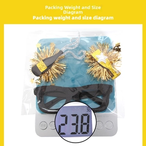Detailed view of black and gold 2026 New Year party glasses being weighed on a scale