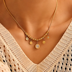 Golden stainless steel Roman numeral necklace set with zircon pendants on model neck