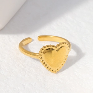 Adjustable gold plated stainless steel heart ring with beaded edge on white background
