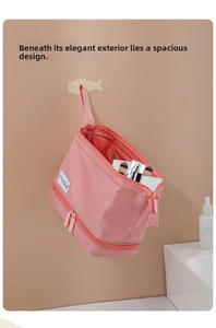 Pink double-layer makeup bag with handle hanging in bathroom for toiletries