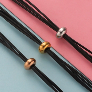 Three-color polished metal rings on black braided cords in silver, gold, and rose gold