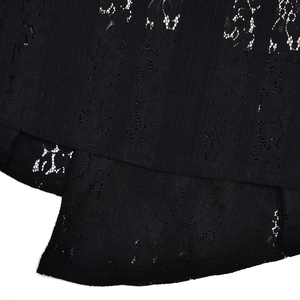 Dettaglio della trama del pizzo nero e delle cuciture fini sull'orlo del vestito elegante