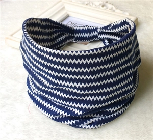 Detail of bohemian blue and white wavy print headband on a soft white carpet texture