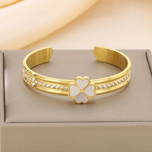 Détail de bracelet trèfle doré avec pétales en nacre et cristaux sur un coffret