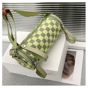 Close-up of checkered cylinder bag showing pleated green texture and metal rivets