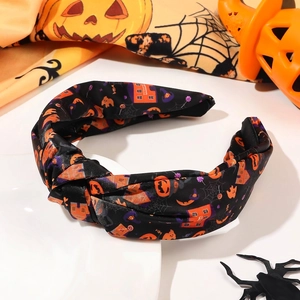 Detail of Halloween knotted headband featuring pumpkin, bat and ghost patterns on black fabric