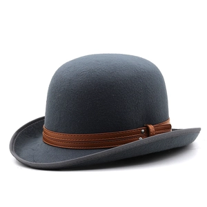 Detail of grey wool bowler hat featuring a brown faux leather band and silver metal rivets