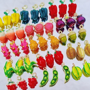 Macro shot of assorted colorful fruit and vegetable alloy charms with golden hanging loops