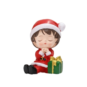 Poupée de Noël en résine avec costume rouge et cadeau vert sur fond blanc épuré