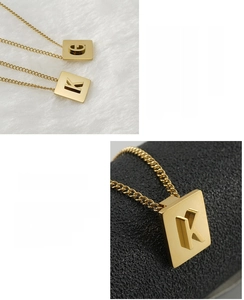 Detailed macro view of 18K gold plated stainless steel square pendants with letters G and K