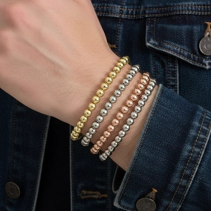 Set of four elastic gold-plated bead bracelets in gold, silver, rose gold, and grey finish