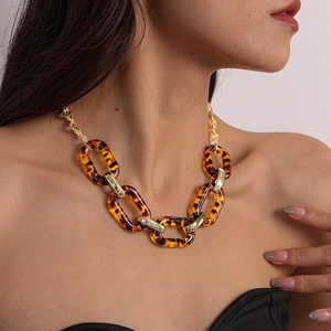 Close-up of tortoise shell acrylic chain necklace with chunky gold metal links