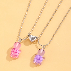 Detail of luminous turtle magnetic necklaces for couples with glowing resin pendants