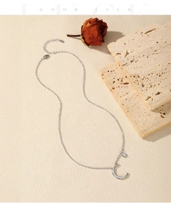 Detail of S925 sterling silver moon and star pendant necklace on textured stone background
