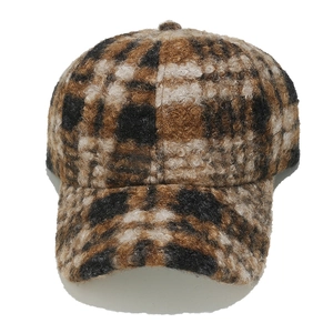 Detailed view of the thick brown and black plaid faux shearling fabric on baseball cap