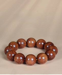 Vue macro d'un bracelet en perles de bois Dalbergia montrant le grain naturel sombre