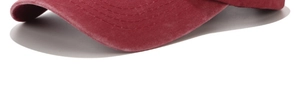 Detailed close-up of wine red washed cotton fabric with stitching on the baseball cap brim