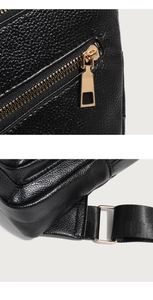 Detail of gold metal zipper and textured lychee pattern PU leather on black crossbody bag