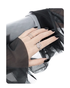 Detail of S925 silver rings with irregular wave design and pink crystal on model hand