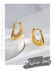 Detail of minimalist gold U-shape earrings featuring an S925 hallmark on a white tray