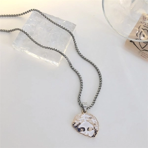 Detail of silver box chain necklace featuring a black and white Venus portrait pendant