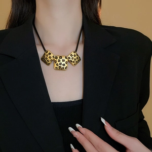 Detail der Vintage-Halskette mit Leopardenmuster, getragen von einem Model im Blazer