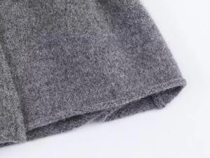 Dettaglio dell'orlo del cappotto di lana grigio con cuciture e trama delle fibre