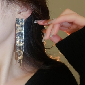 Close-up of leopard print drop earrings with sparkling rhinestones and black gold finish