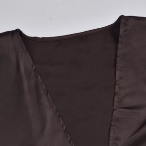 Detail view of deep brown satin crop top featuring a V-neckline and smooth silk texture