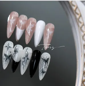 Detailed view of long stiletto nails with butterfly patterns and gothic cross designs