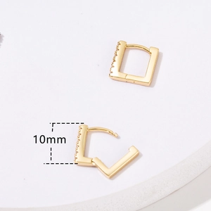 Dettaglio di orecchini a cerchio dorati da 10mm con zirconi che mostrano la chiusura aperta e chiusa