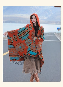 Close-up of ethnic patterned orange hooded shawl with tassels for outdoor travel