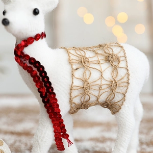 White flocked Christmas reindeer figurine with red sequins and jute net decor